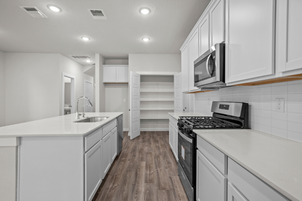 A kitchen with white cabinets.