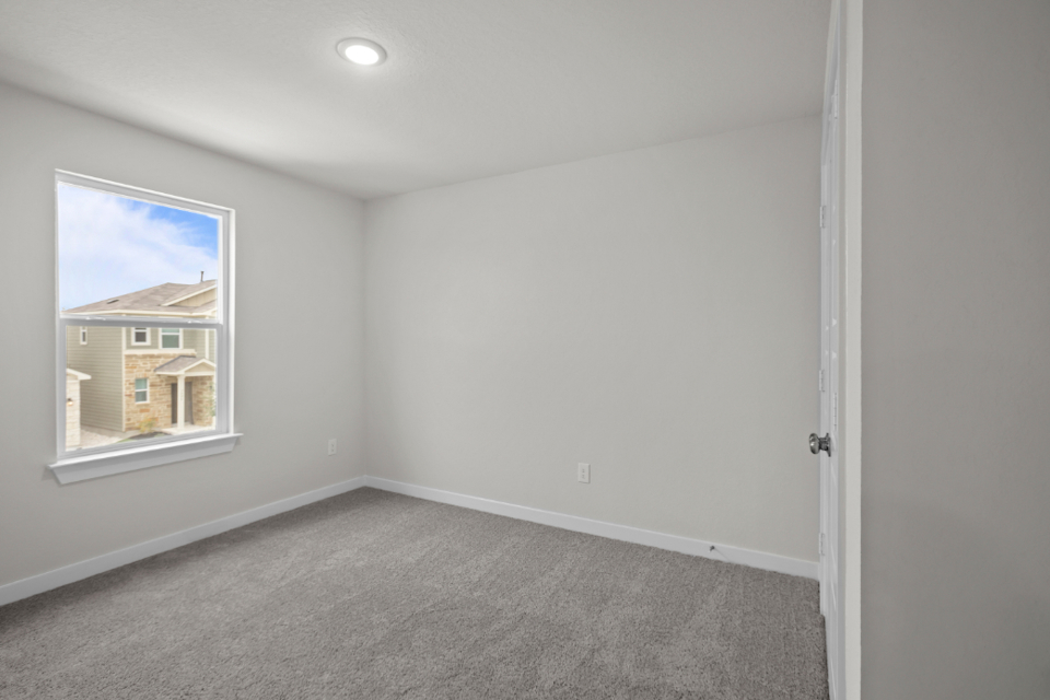 A room with a carpet and a window.