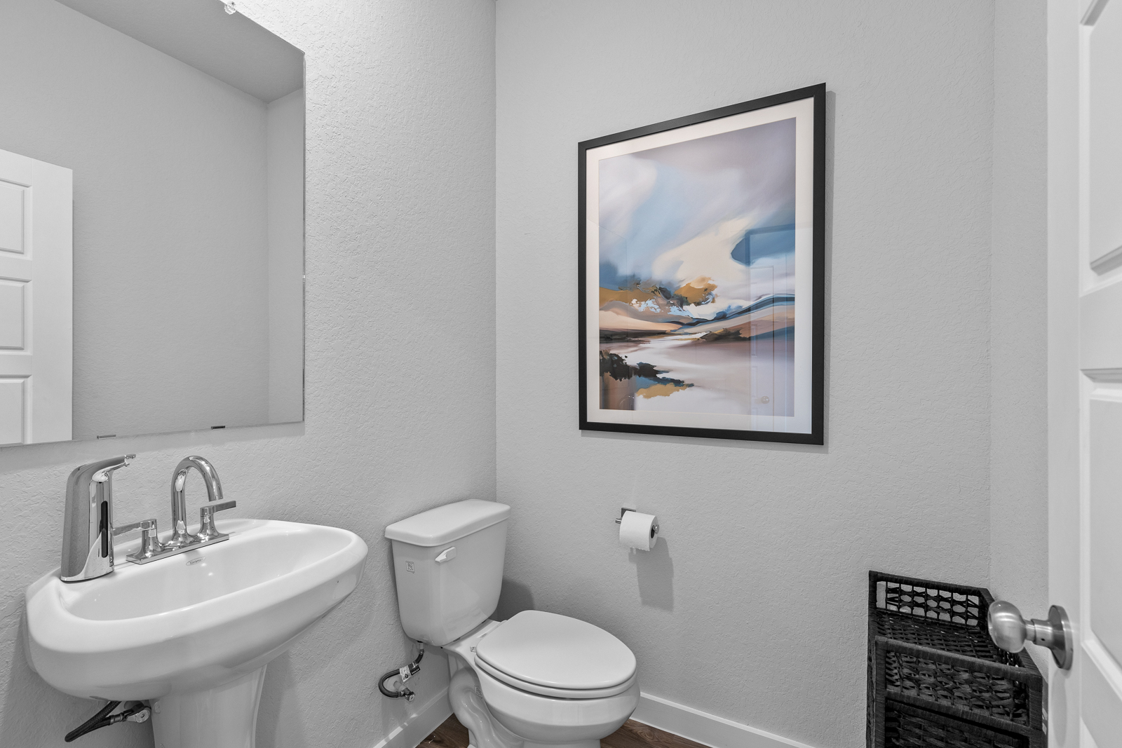 A bathroom with a picture on the wall.
