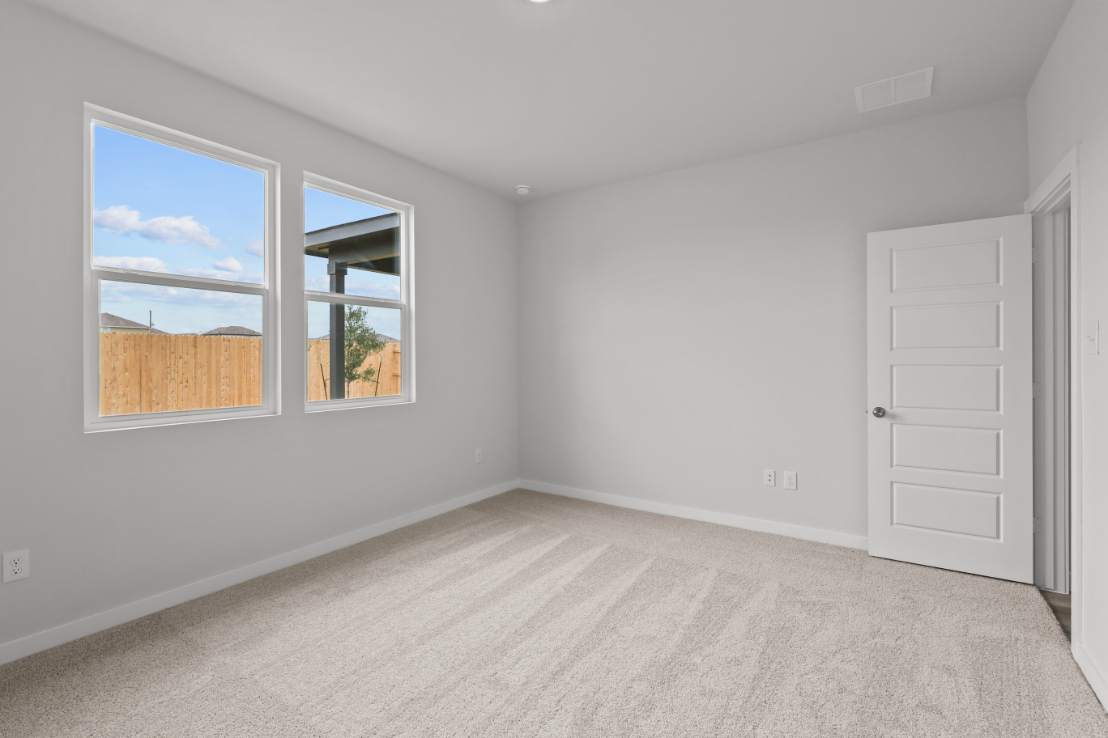 A room with a window and a door with a view of the ocean.