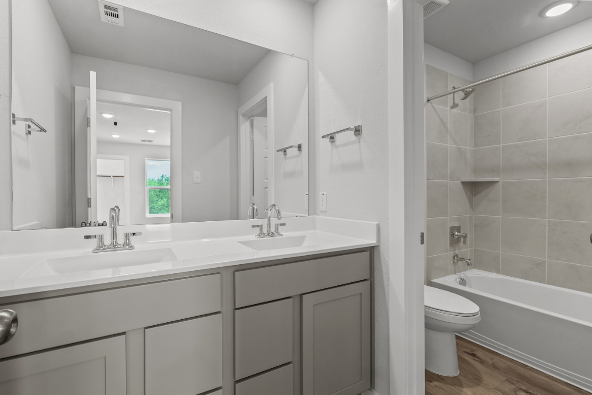 A bathroom with a tub sink and toilet.