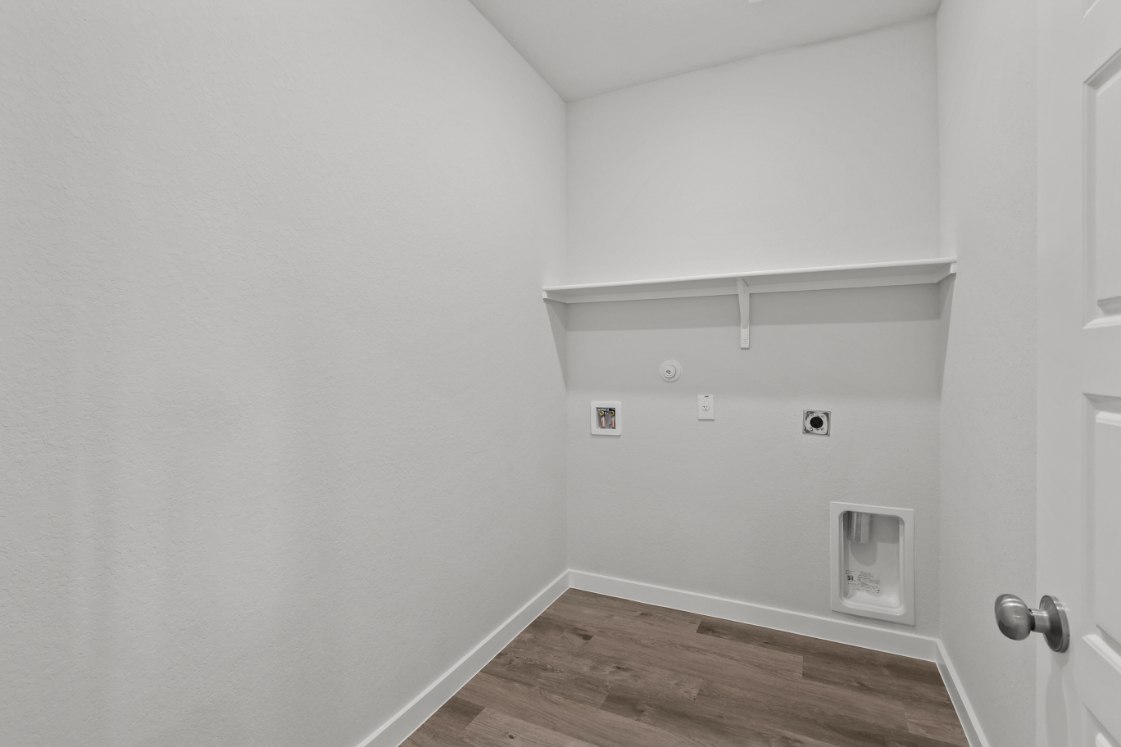 A white room with a wood floor.