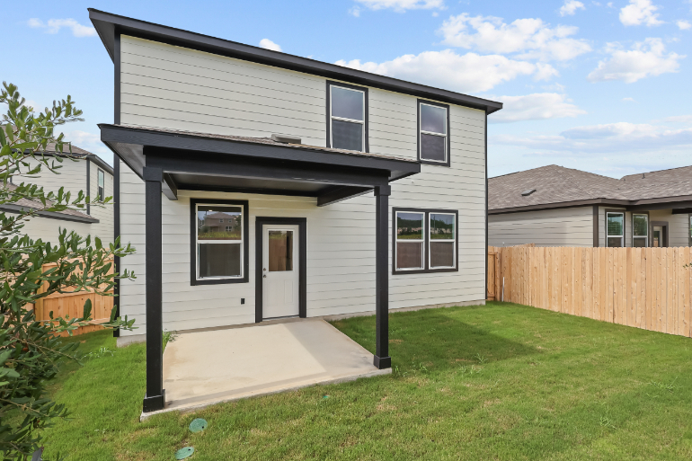 A house with a fence and grass.