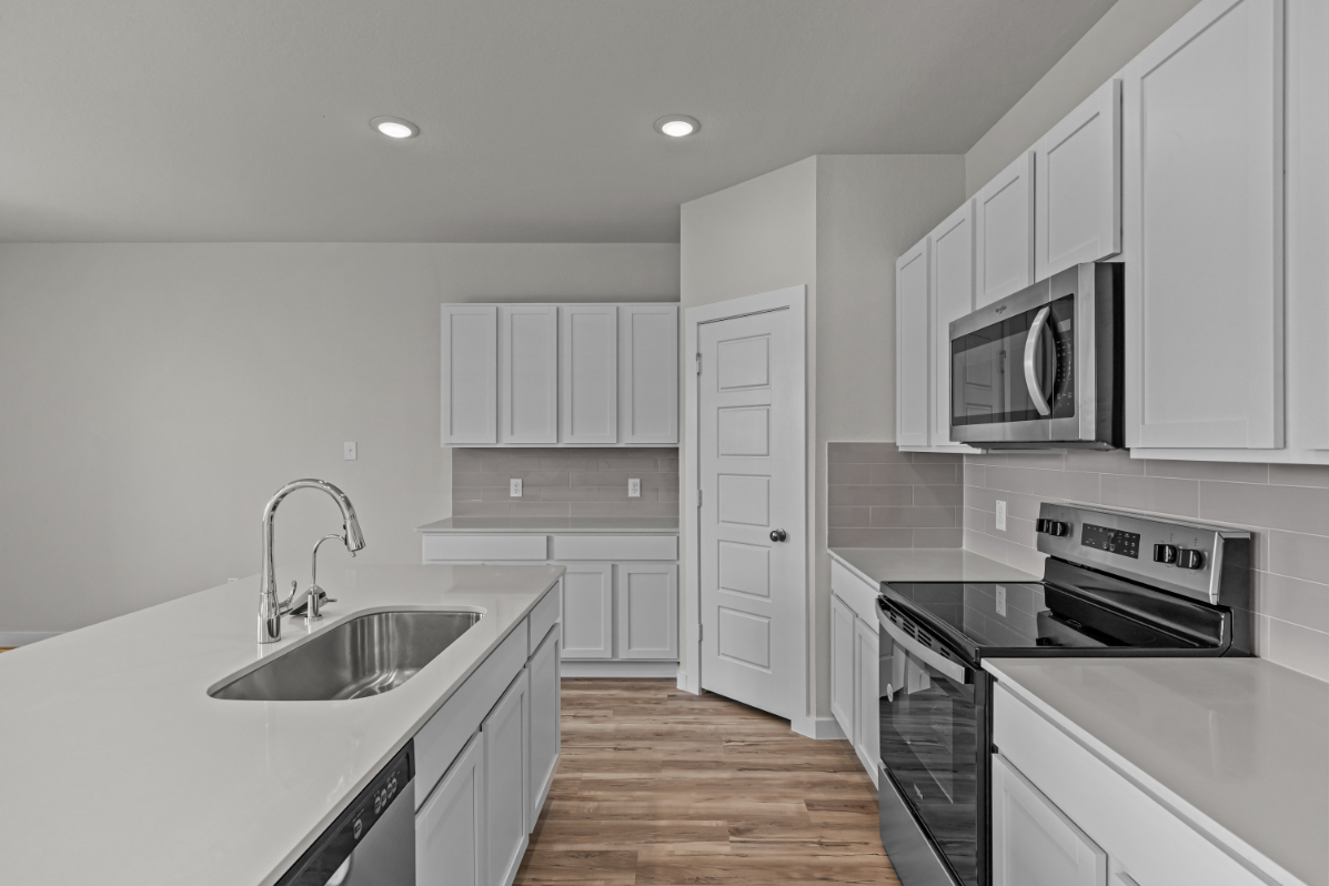 A kitchen with white cabinets.