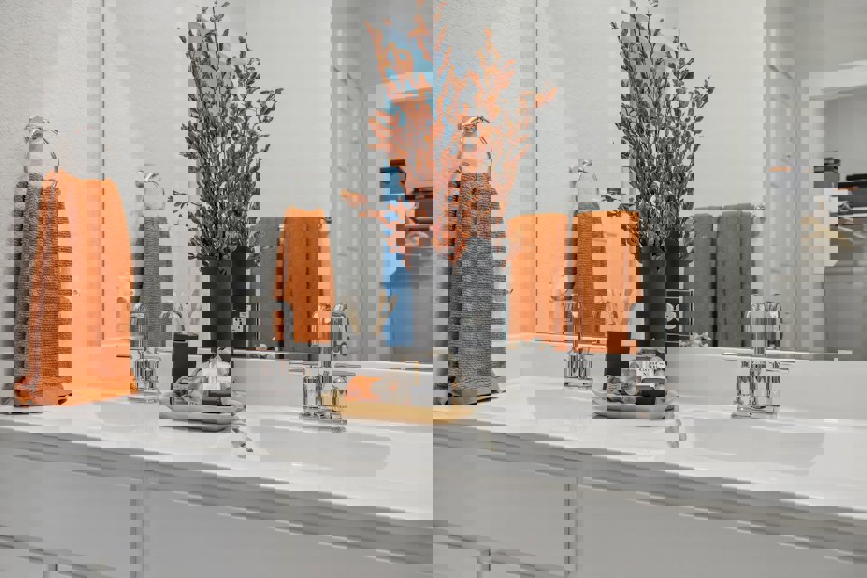 A bathroom with a vase of flowers.