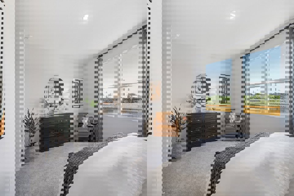 A bedroom with a bed and a mirror.