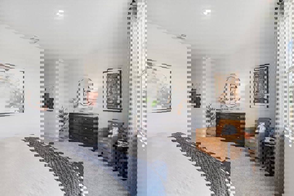 A bedroom with a bed and a chair.