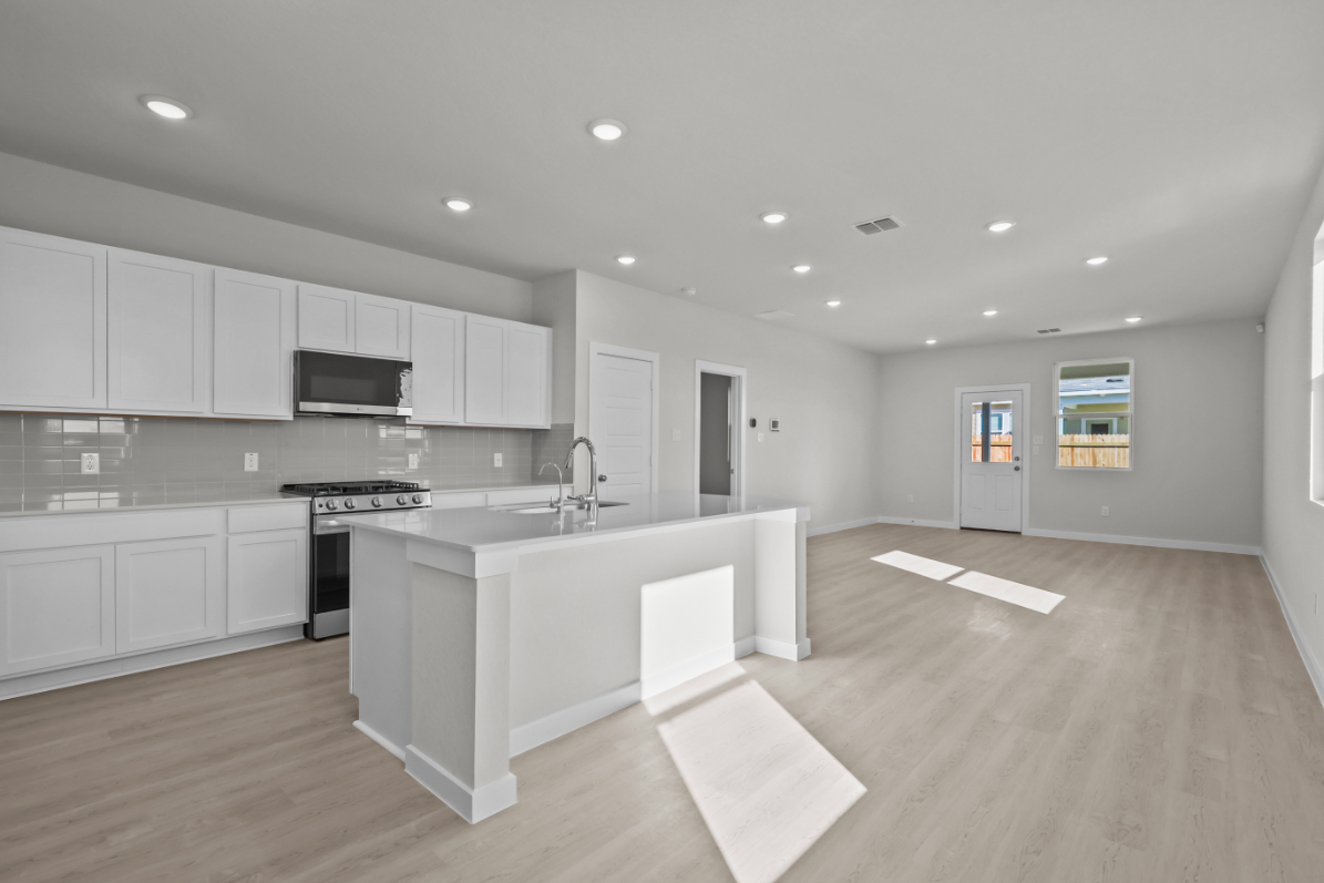 A kitchen with white cabinets.