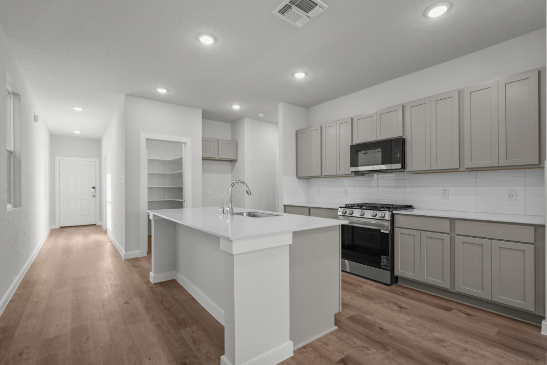 A kitchen with white cabinets.