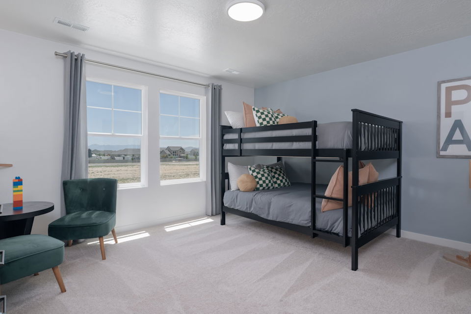 A bedroom with a bed and a chair.