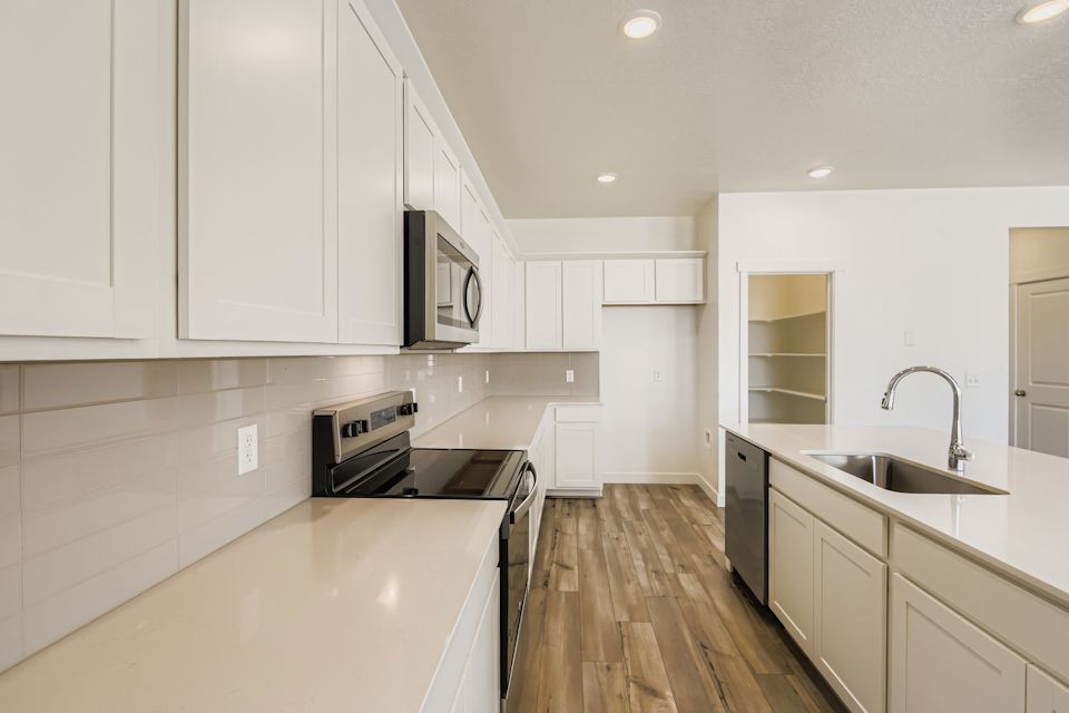 A kitchen with white cabinets.