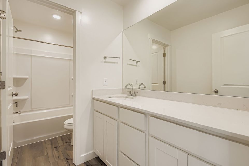 A bathroom with a tub sink and toilet.