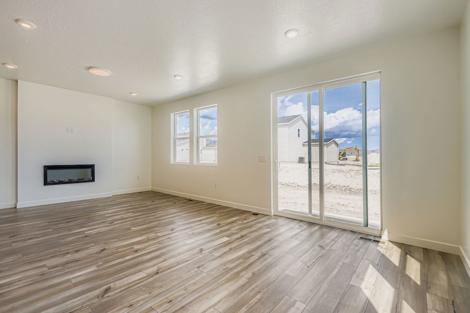 A room with a wood floor and a large glass door.