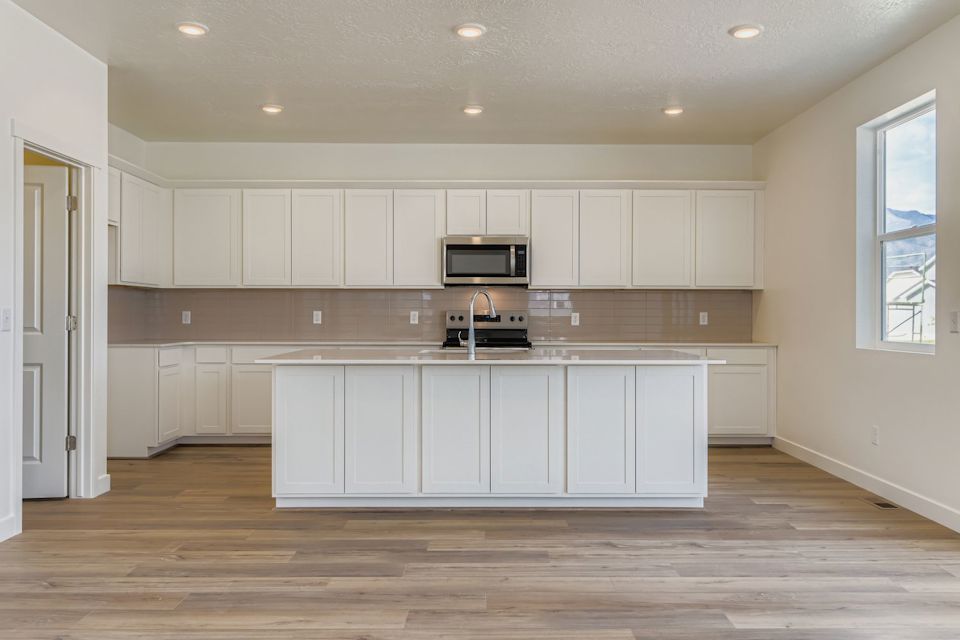 A kitchen with white cabinets.