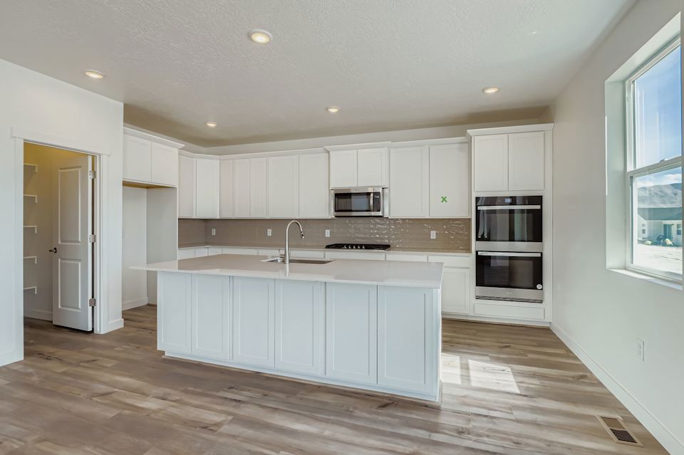 A kitchen with white cabinets.
