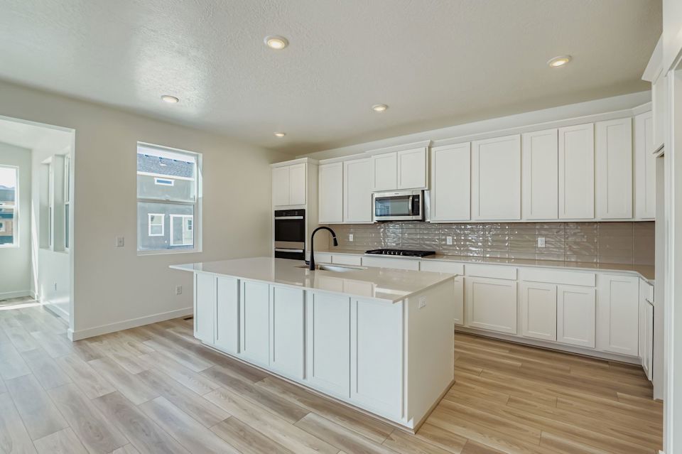 A kitchen with white cabinets.
