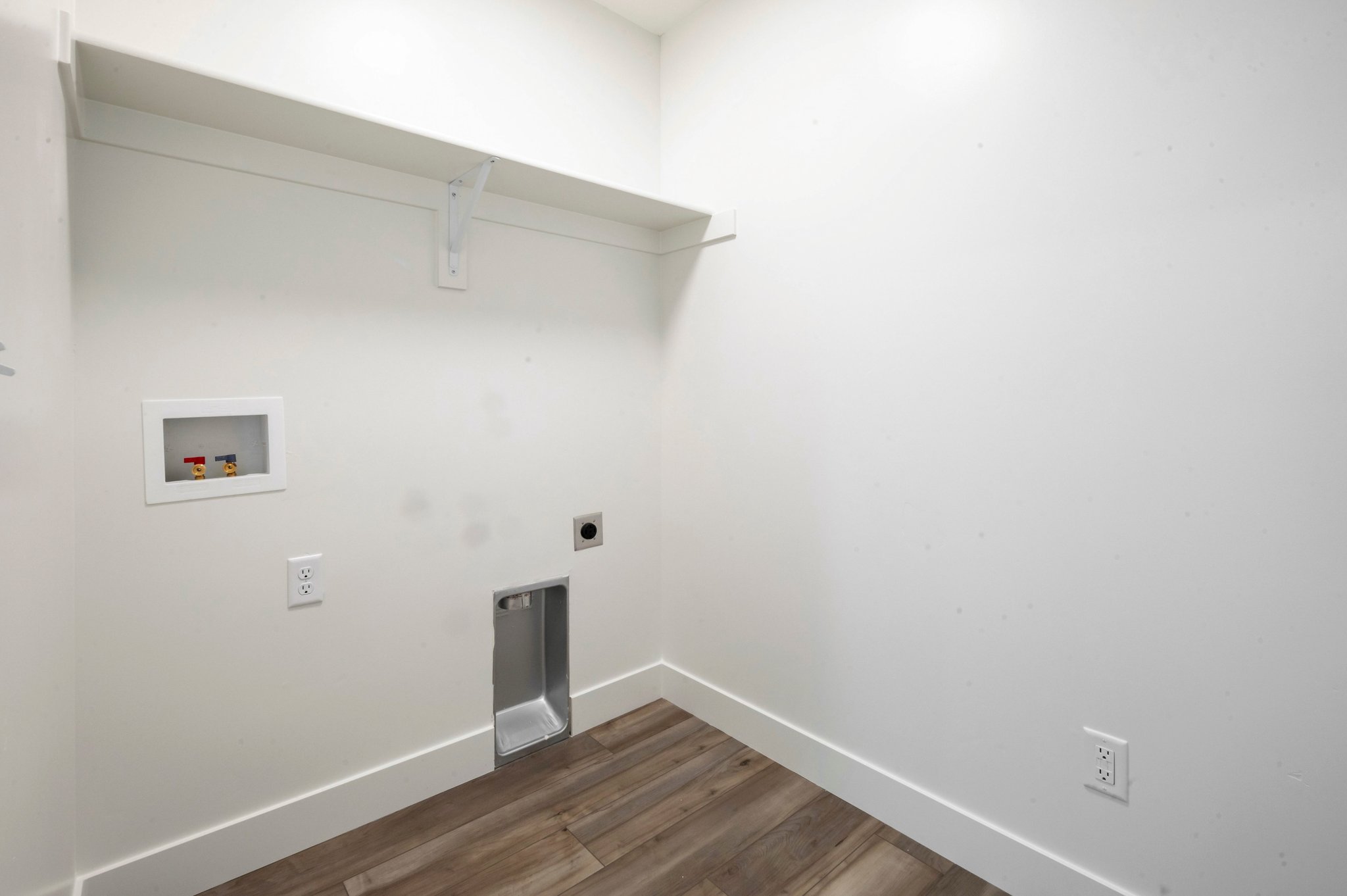 A white room with a wood floor.