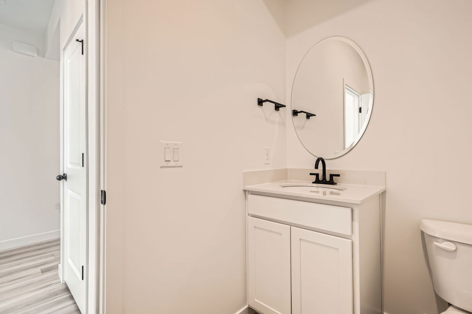 A bathroom with a round mirror.