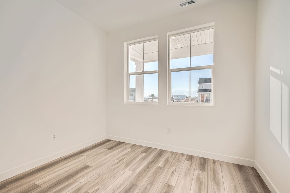 A room with a wood floor and windows.