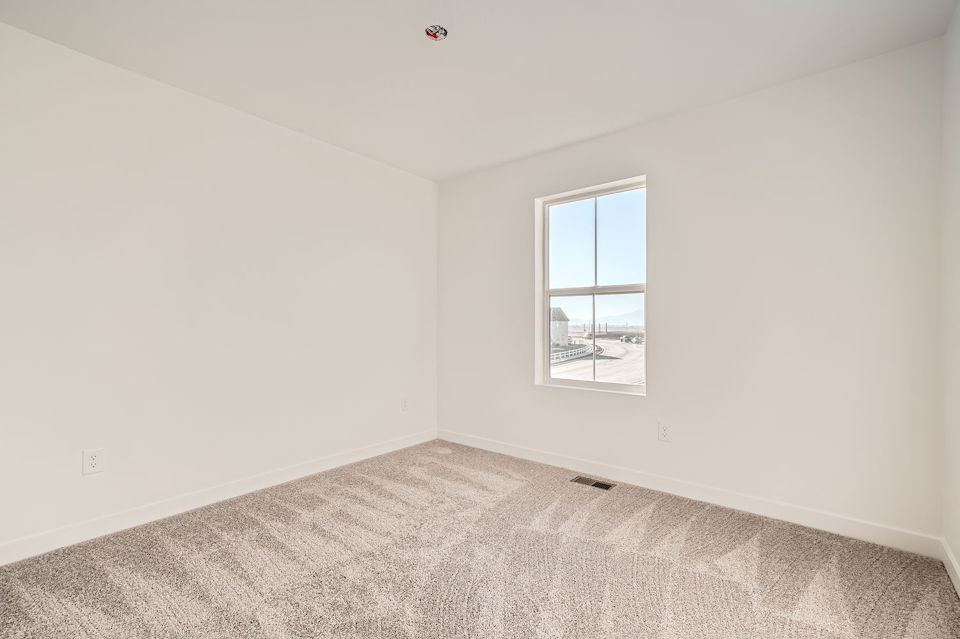 A room with a window and carpet.
