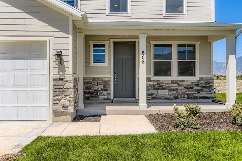 A house with a garage and a stone patio.