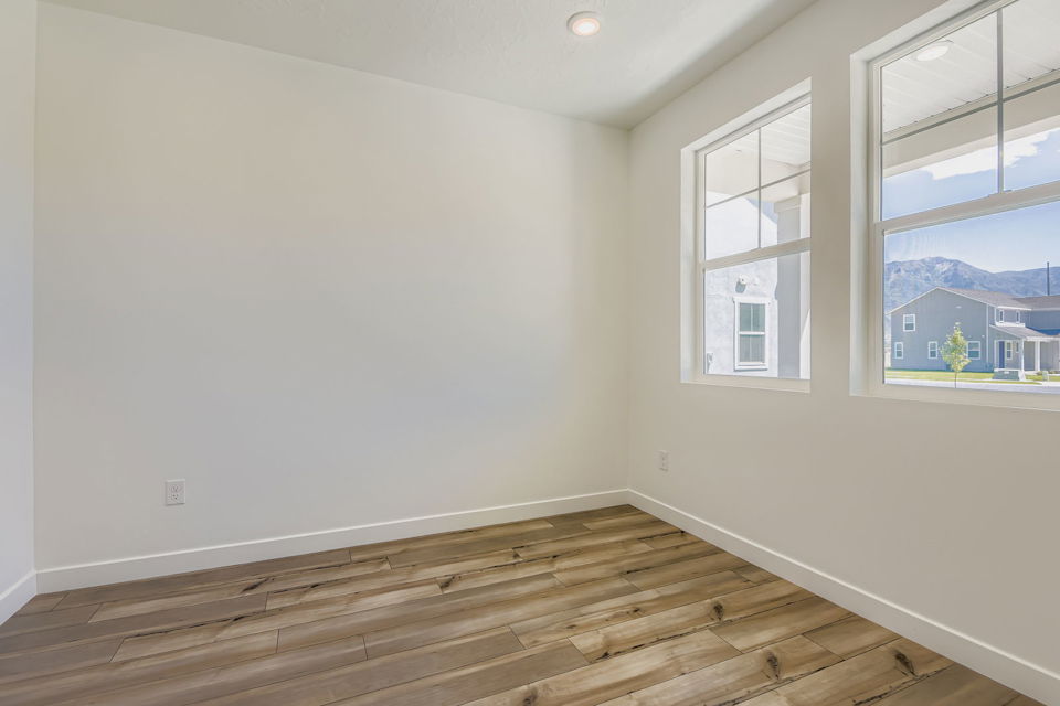 A room with a wood floor and windows.