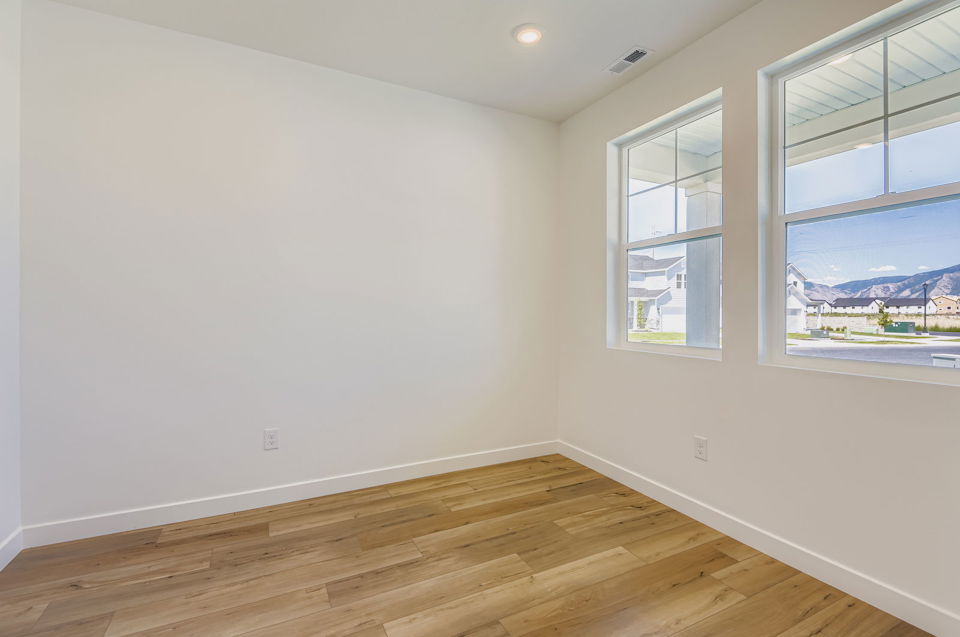 A room with windows and a wood floor.