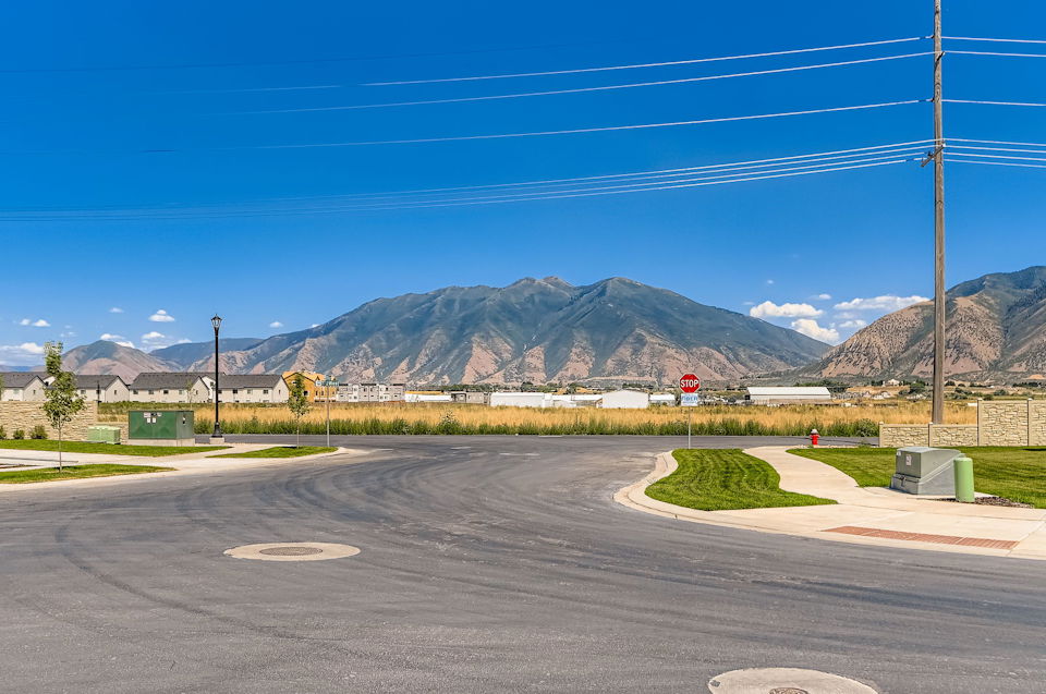 A road with a sign on it and mountains in the background.