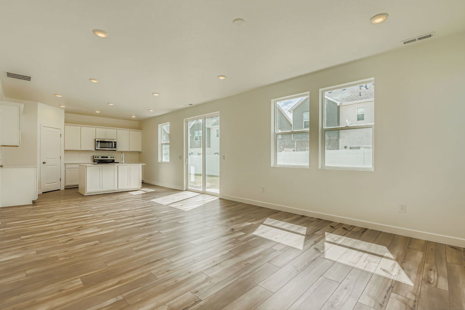 A large empty room with white cabinets.