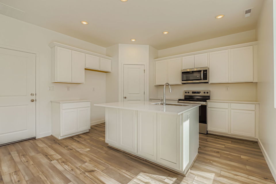 A kitchen with white cabinets.