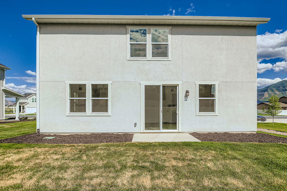 A white house with a grass yard.
