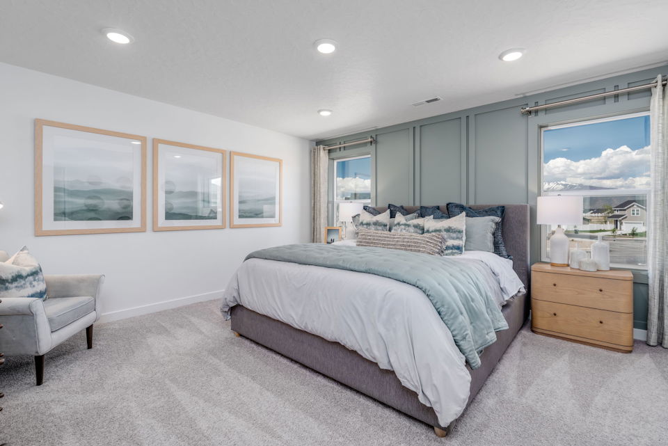 A bedroom with a bed and a chair.