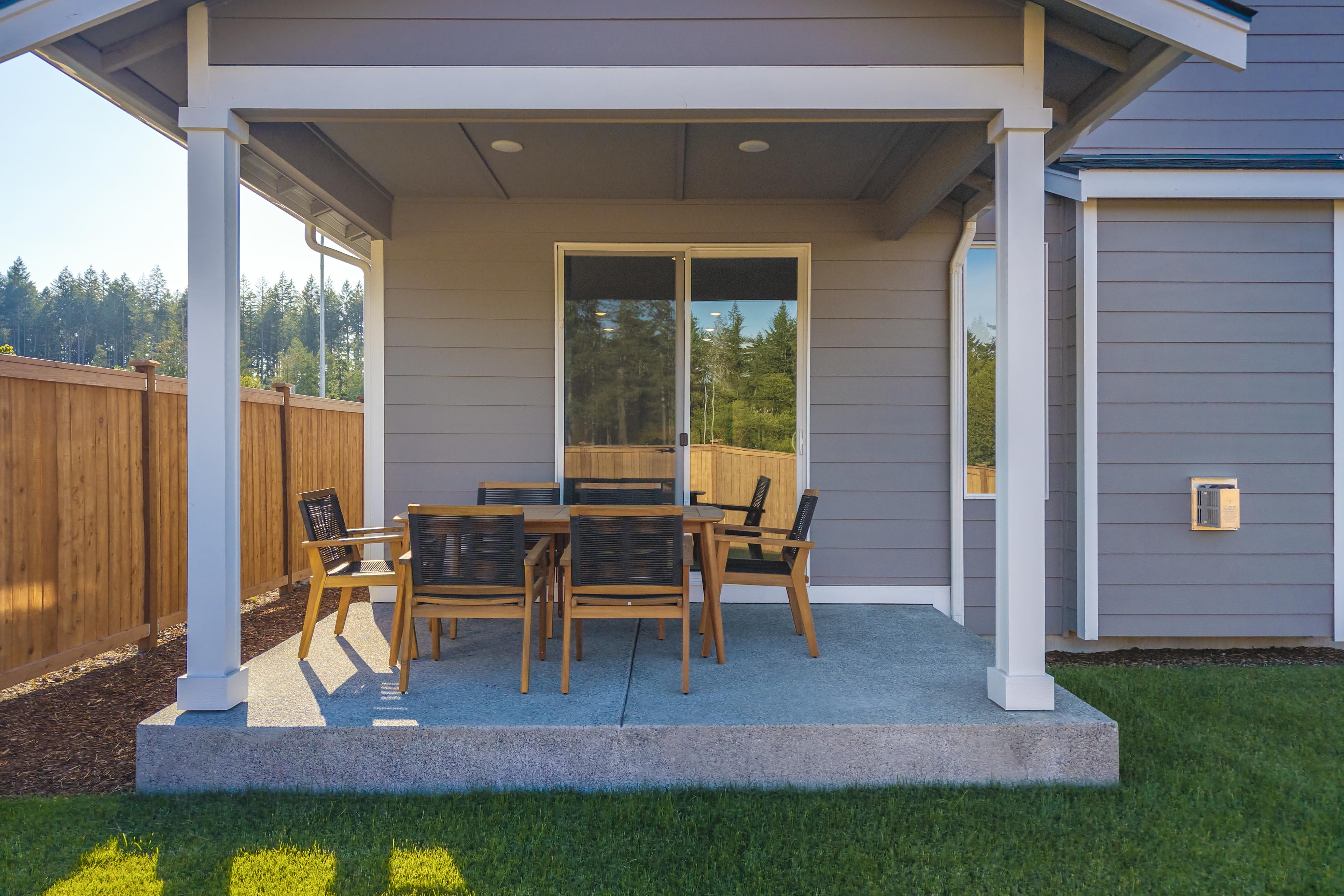 A patio with chairs and a table.