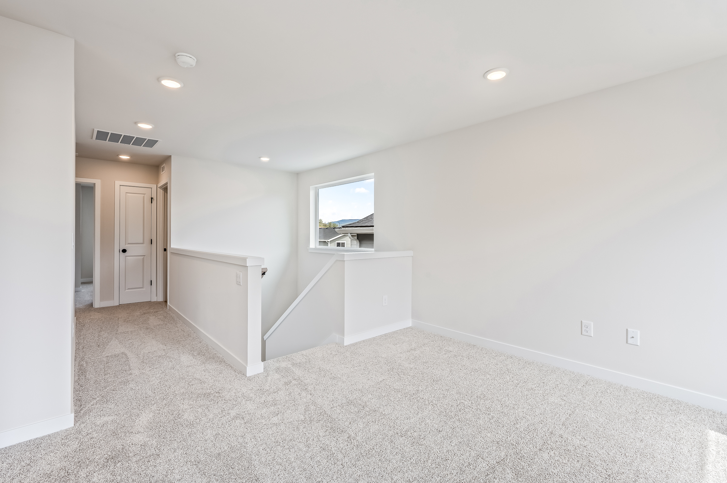 A room with white walls and a tv on the wall.