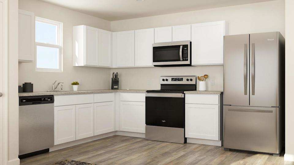 A kitchen with white cabinets.