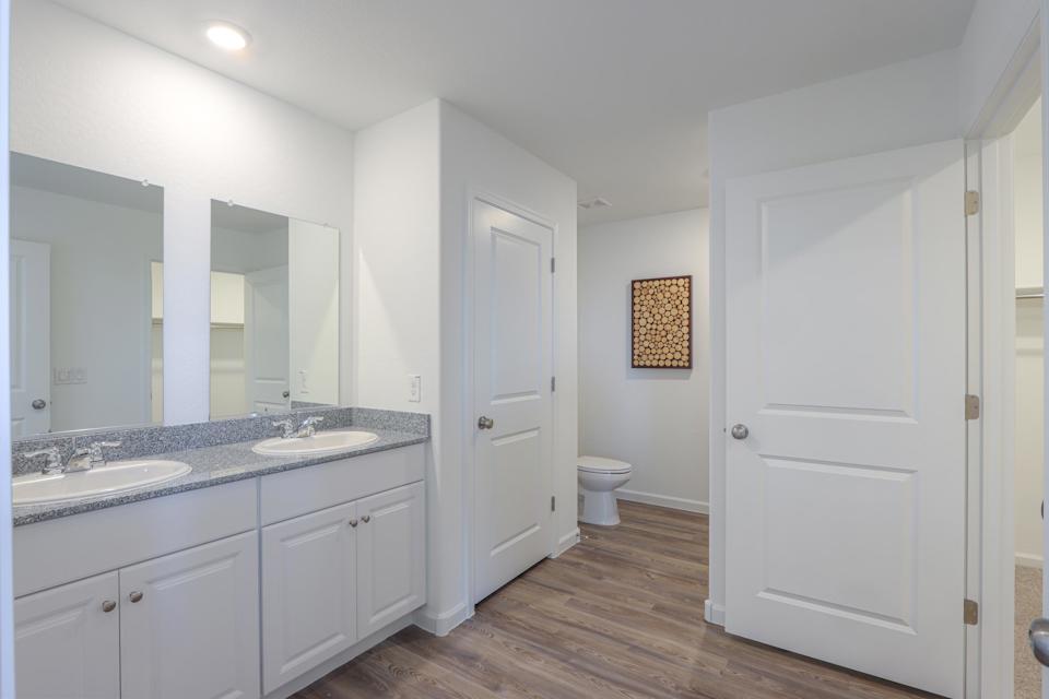 A bathroom with white cabinets.