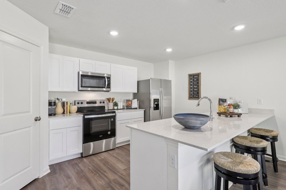 A kitchen with white cabinets.