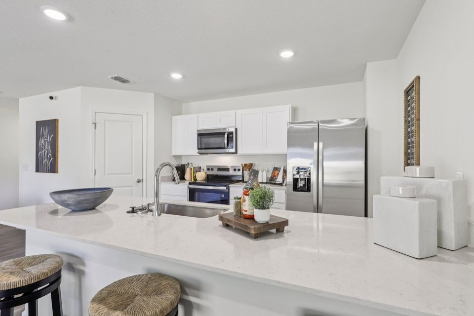 A kitchen with white cabinets.