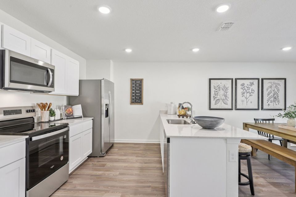A kitchen with white cabinets.