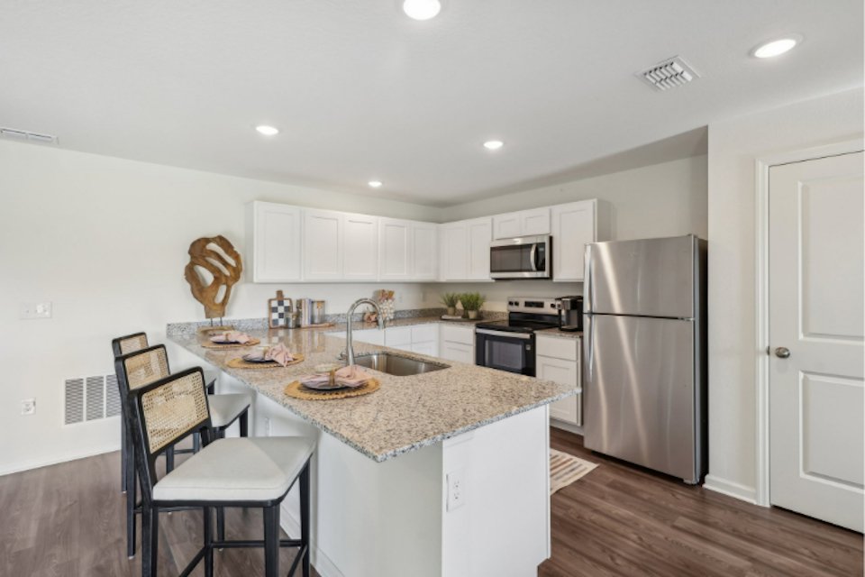A kitchen with white cabinets.