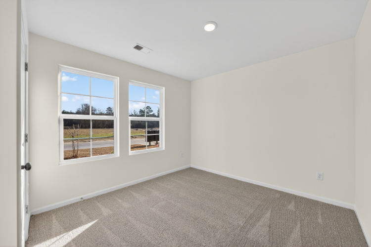 A room with a window and a carpet.