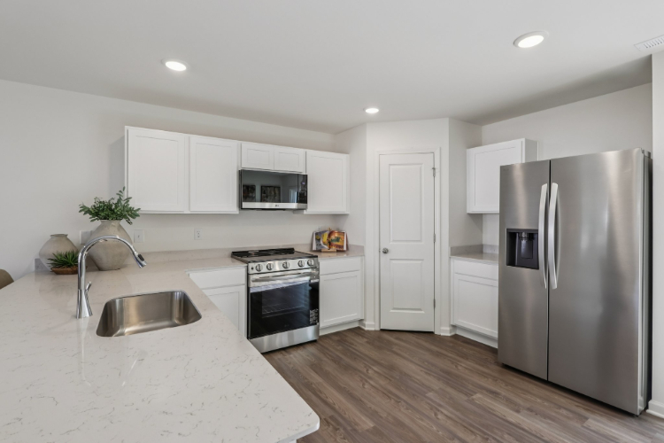 A kitchen with white cabinets.