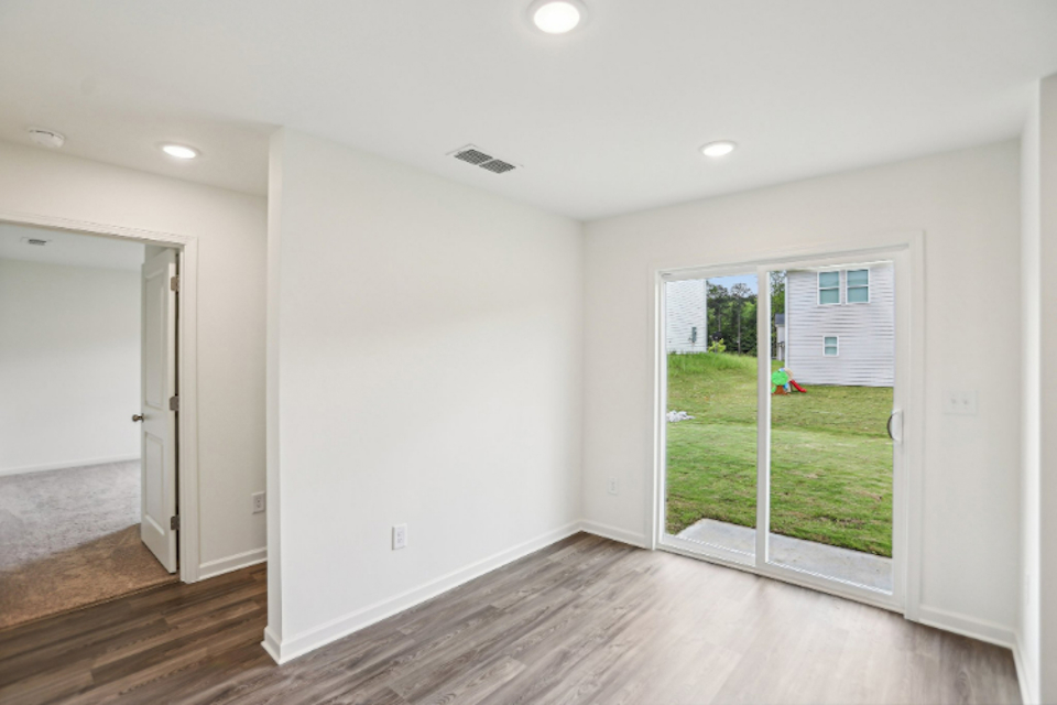 A room with a wood floor and a glass door.