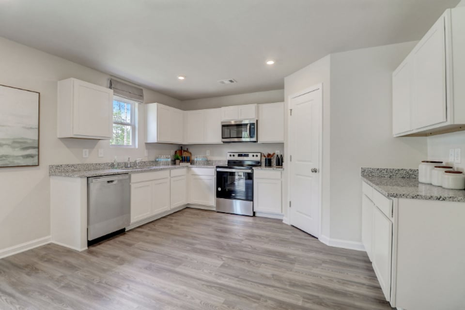 A kitchen with white cabinets.