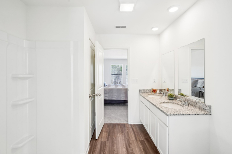 A bathroom with white cabinets.