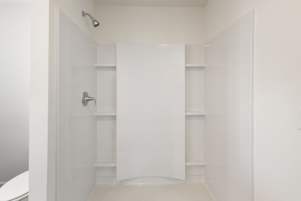 A bathroom with white cabinets.