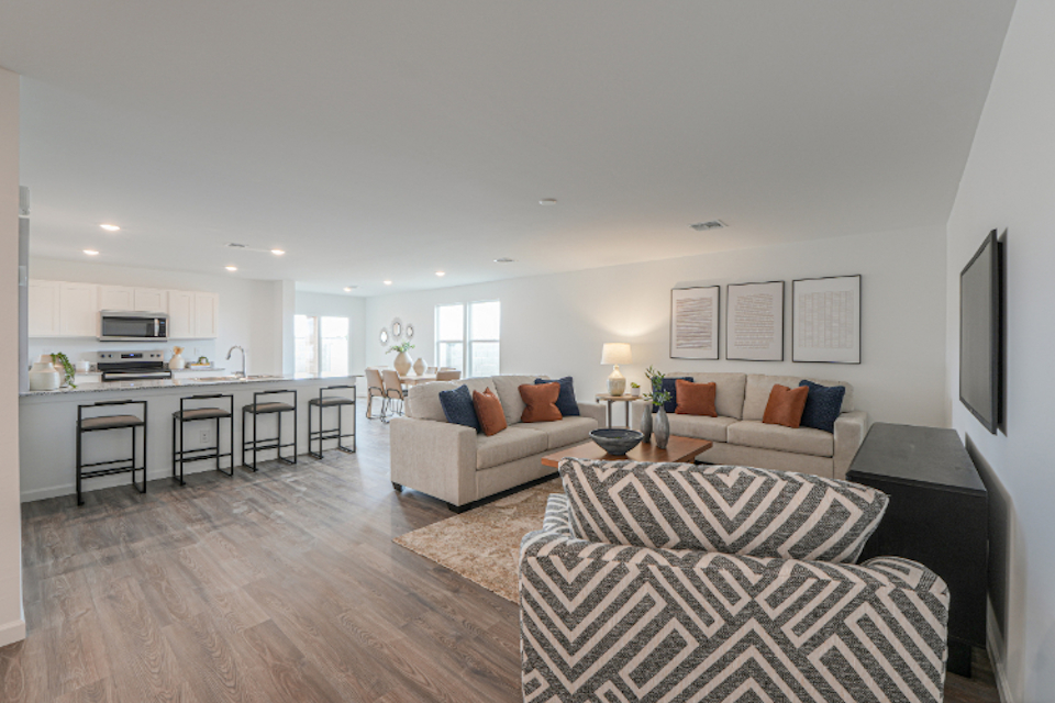 A living room with a large kitchen.