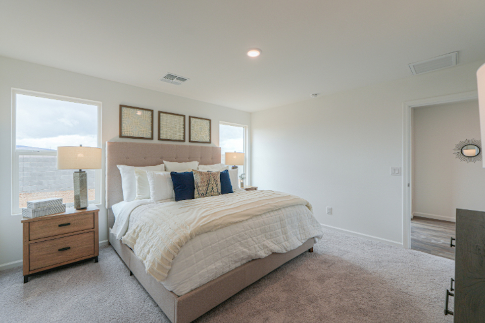 A bedroom with a bed and a lamp.