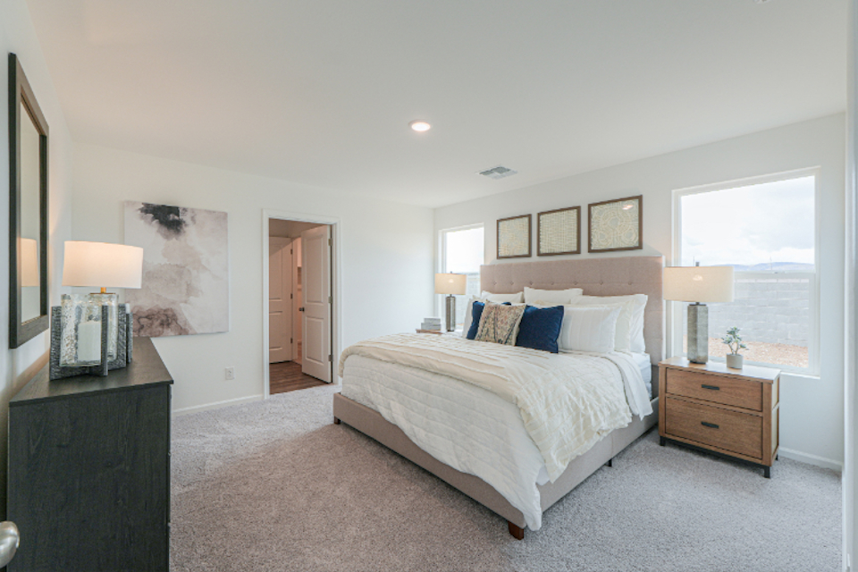 A bedroom with a bed and lamps.