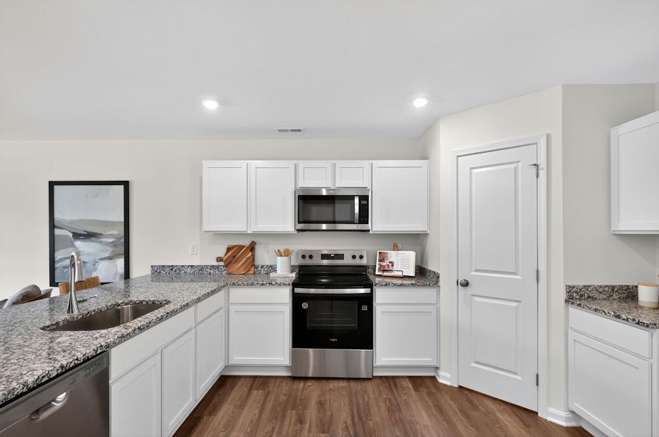 A kitchen with white cabinets.